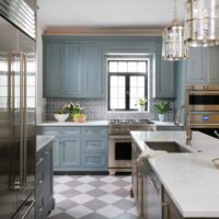 Vintage inspired kitchen with checkboard floor, gray painted cabinets and stained wood cabinets