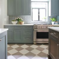 Gray painted and wood stained cabinets in a vintage inspired kitchen with checkered floor tile