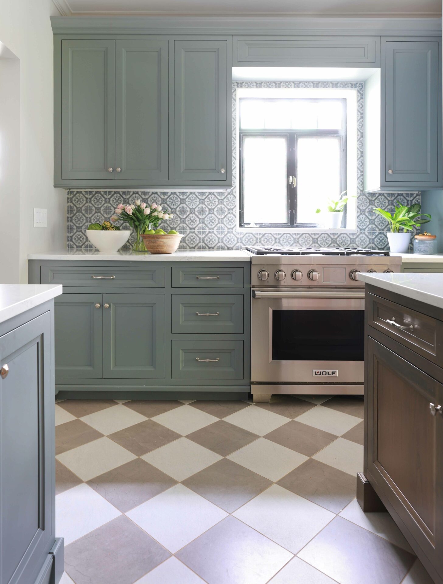 Gray painted and wood stained cabinets in a vintage inspired kitchen with checkered floor tile