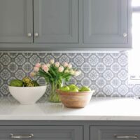 Gray kitchen cabinetry with patterned backsplash tile