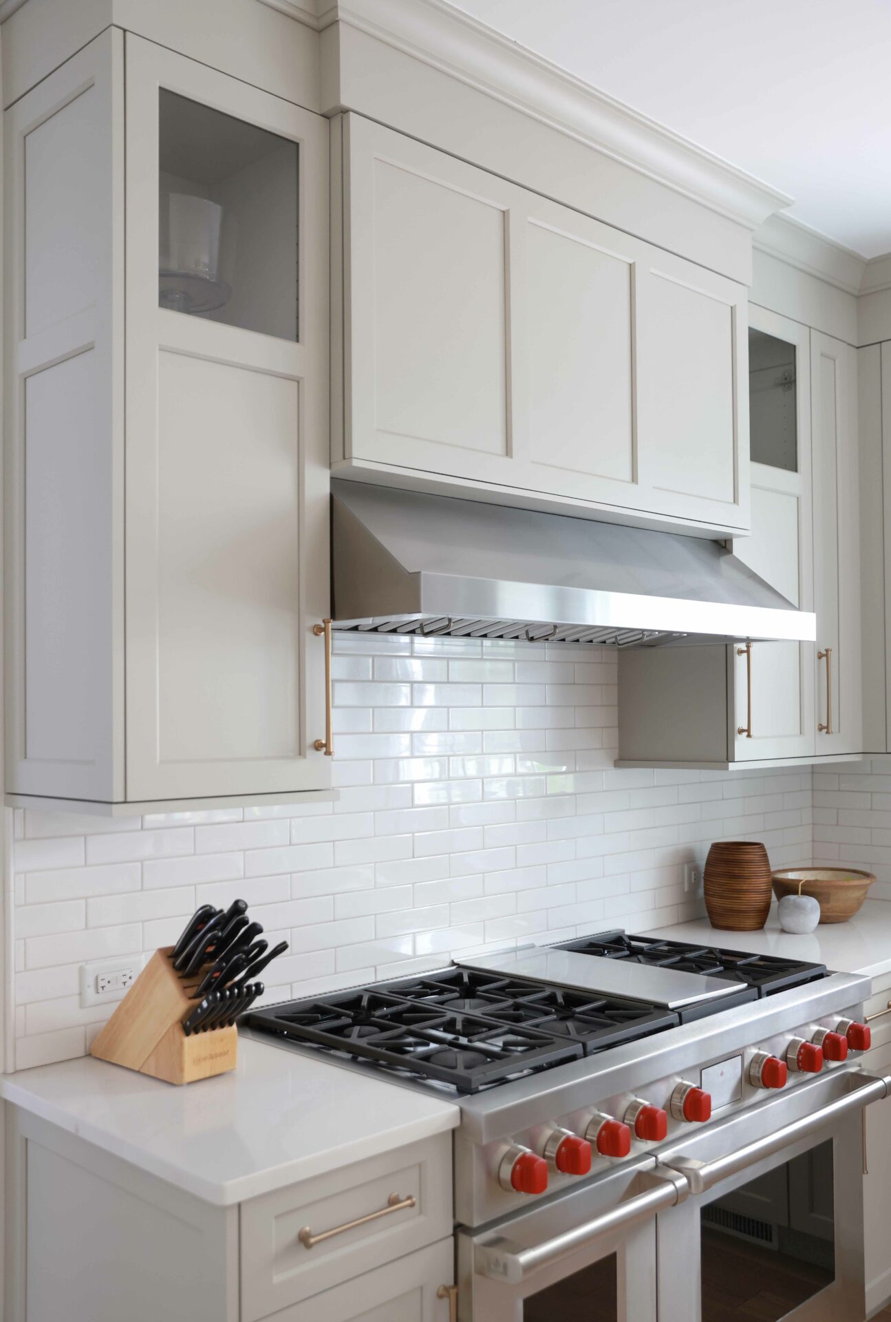 Warm white kitchen cabinets with a stainless steel hood