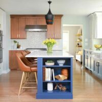 U shaped kitchen with island featuring walnut cabinets, white painted cabinets, and blue painted kitchen cabinets