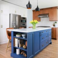 Blue kitchen island paired with white cabinets and walnut cabinets