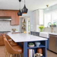 Three color kitchen cabinets are walnut, white and blue, with blue island