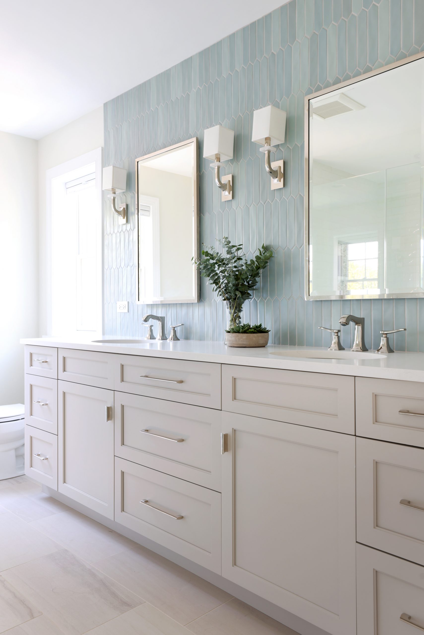 Primary bathroom with warm gray cabinets and blue tile