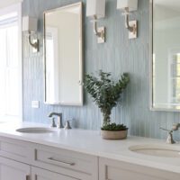 primary bathroom with a double vanity and blue backsplash tile