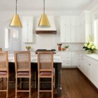 White kitchen with dark island and stacked cabinets