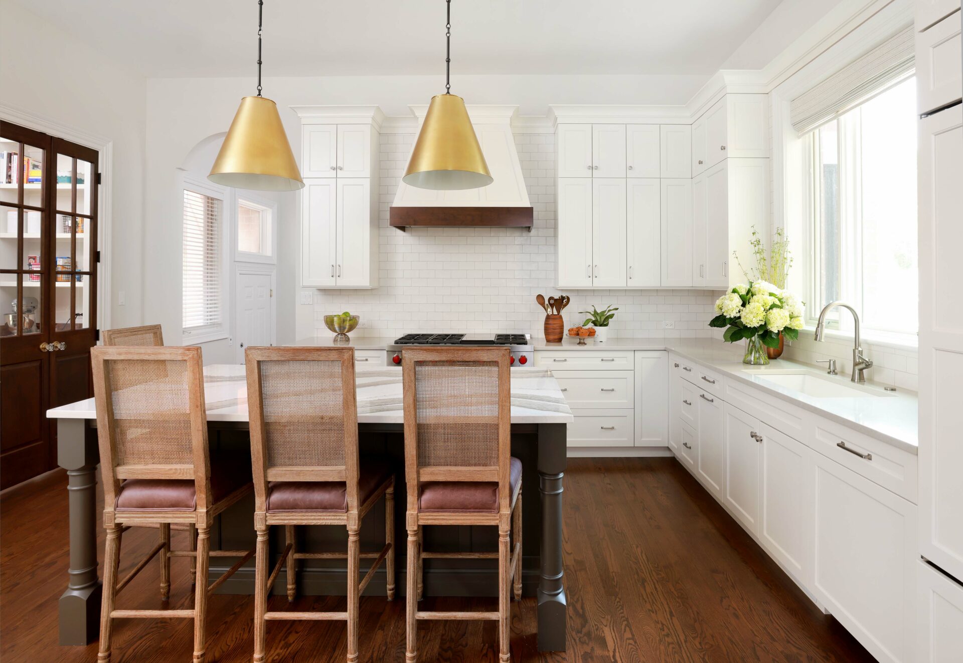 White kitchen with dark island and stacked cabinets