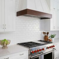 White kitchen cabinets with dark stained hood trim