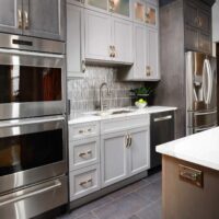 condo kitchen with two tone cabinetry and stainless steel appliances