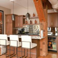 condo entertainment area with wet bar and island showcasing wooden support beam