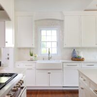 window over apron front sink in white kitchen addition