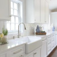 white kitchen with apron front sink and textured back splash