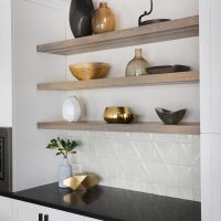 open shelving on textured white wall tile in kitchen