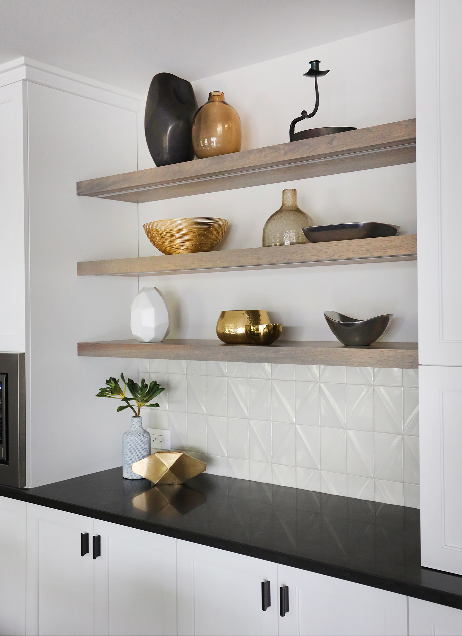 open shelving on textured white wall tile in kitchen