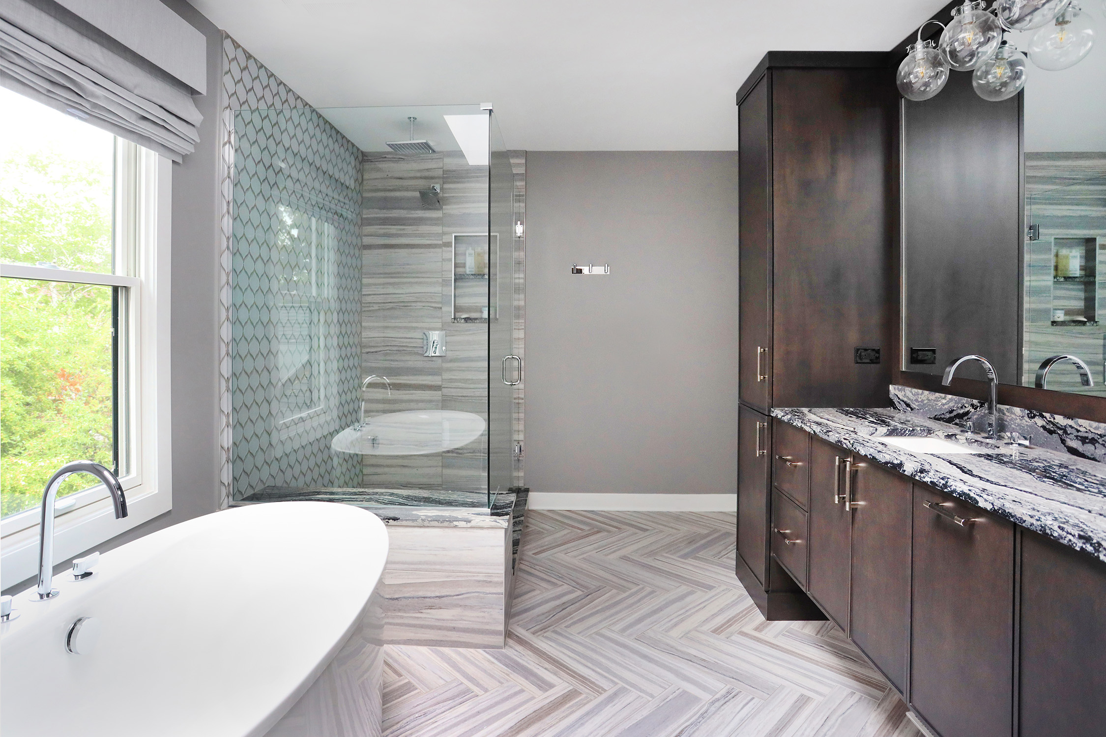 frameless shower and stand alone tub with dark vanity and patterned floor tile