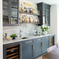 Wet bar with open shelving and painted cabinetry