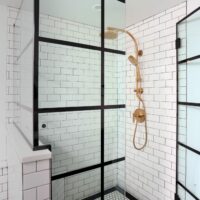 Shower with black grid and gold fixtures