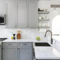 gray kitchen with open shelving and stainless steel sink