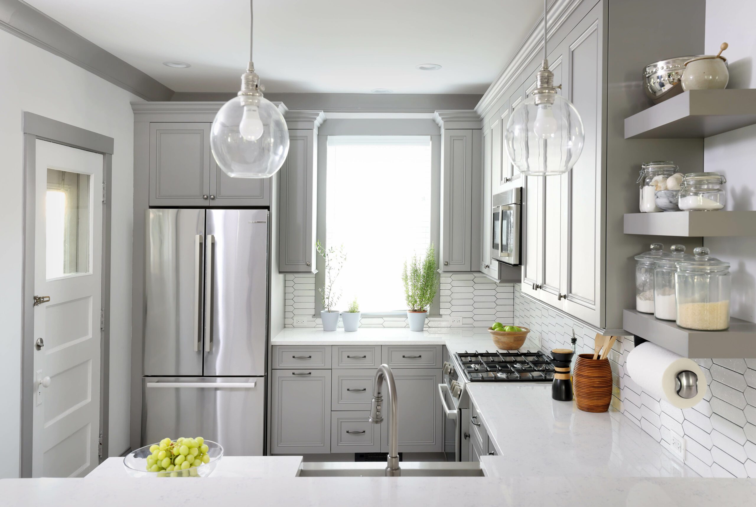 u-shaped gray kitchen with stainless steel sink and white ceramic backsplash