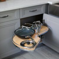 swing out cabinet shelf on lower cabinet in gray kitchen