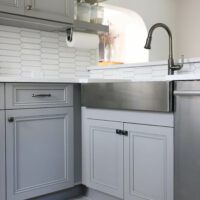 stainless steel apron front sink in gray kitchen