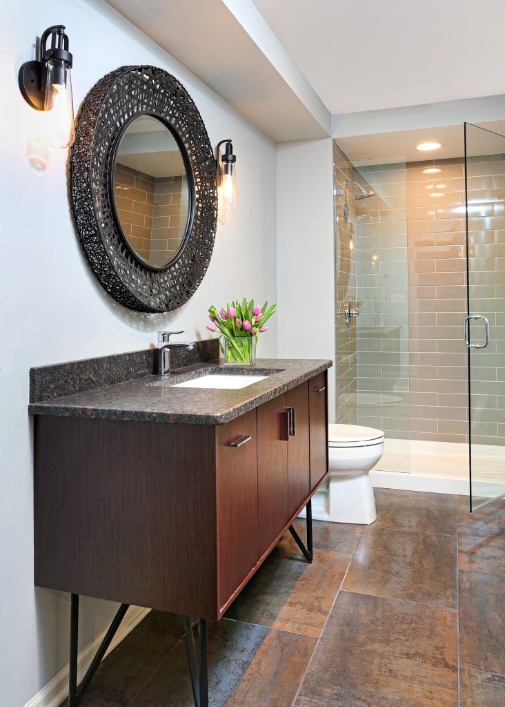 dark stained bathroom vanity and stand alone shower in basement bathroom