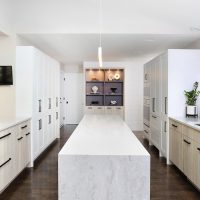 modern white kitchen with laminate cabinets and waterfall edge island