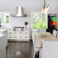 modern kitchen with island and dining table decorated with fine art