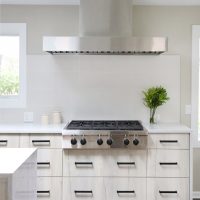 modern kitchen, waterfall edge island, large hood range, tile to ceiling