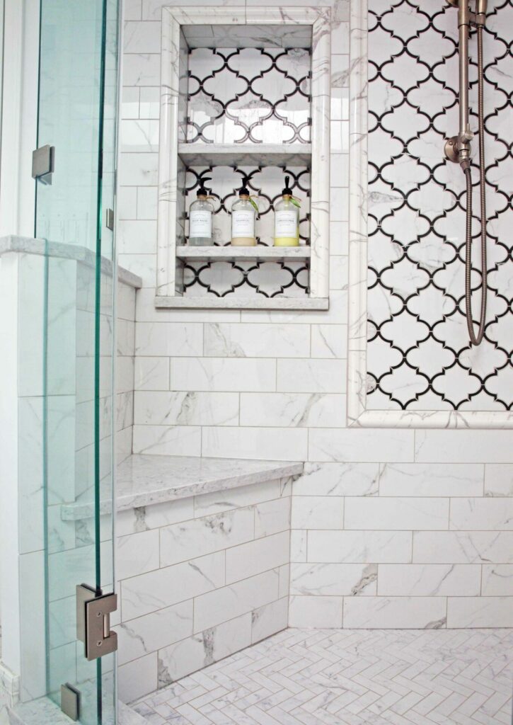 all white shower with accent tile and shaving ledge that doubles as mini bench