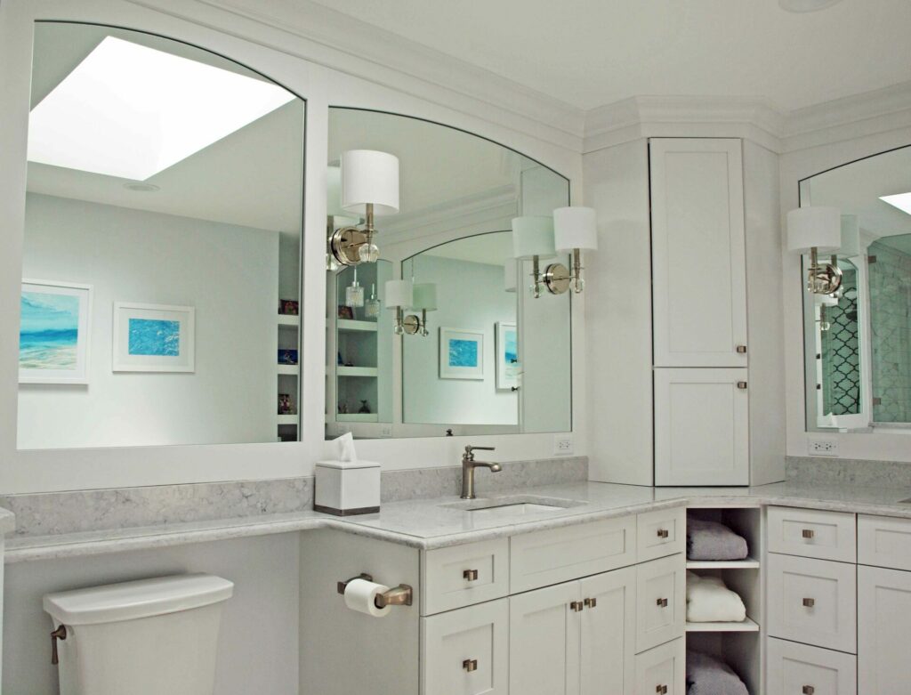 all white bathroom with framed arched mirrors and skylight
