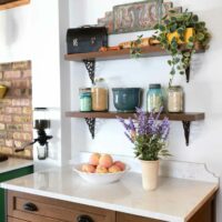 stained kitchen cabinet with open shelves and decorative metal brackets