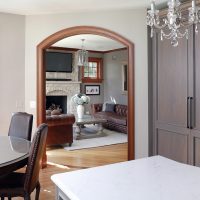 Traditional kitchen dining area with arched doorway and hardwood flooring