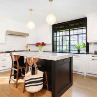 white kitchen with black island and black windows
