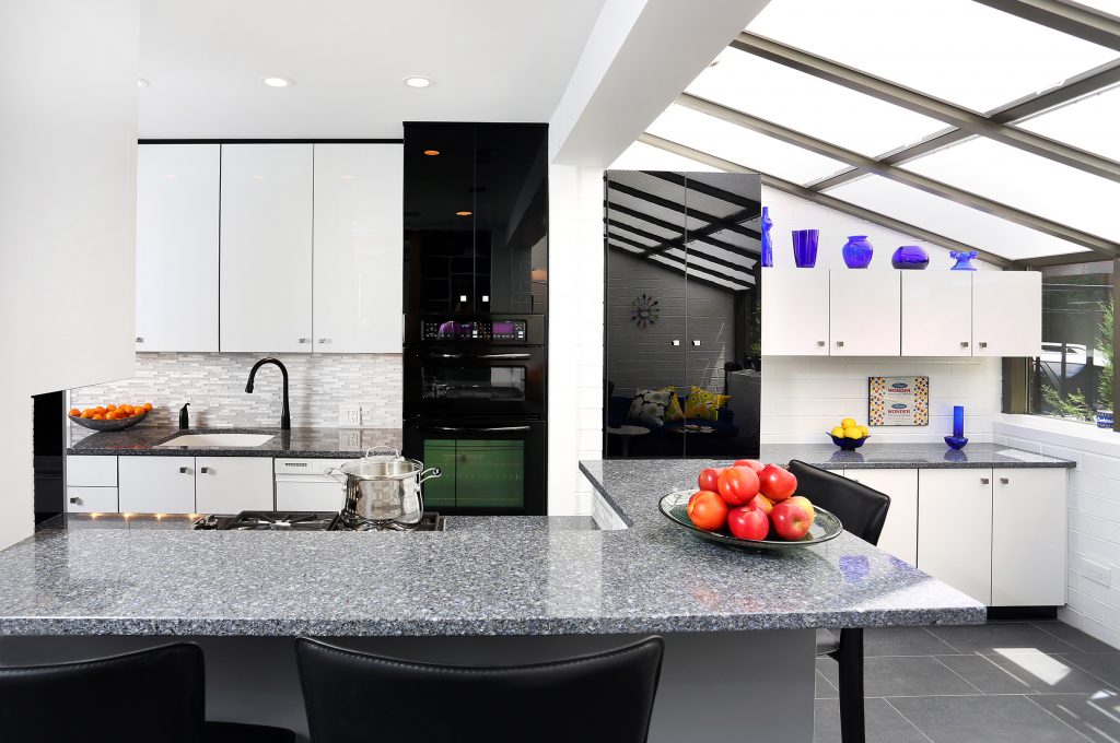 Black and white glossy cabinets in galley kitchen